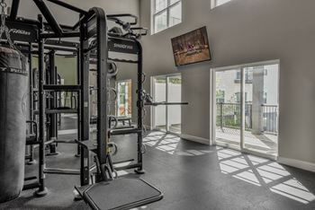 a home gym with weights and a doorway to a balcony